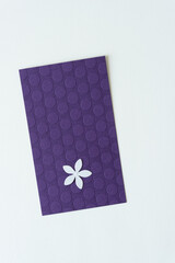 paper flower shaped confetti isolated on purple card with dots