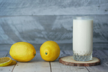 Yellow Lemon and glass of milk on table 