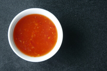 chili tomato sauce in a small jar on table 
