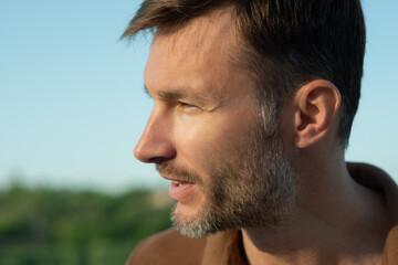 Fototapeta premium One man with stubble looks to the side, close-up.