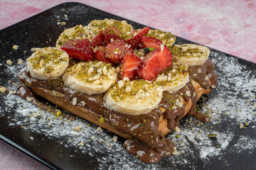 Belgian waffles with chocolate sauce and and fresh fruits.
