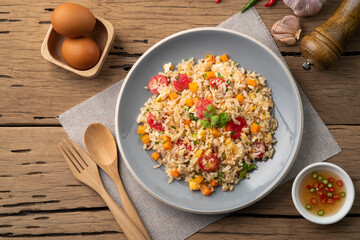 Sausage Fried rice.Stir fried Thai rice with hot dog ,carrot and eggs in gray plate on wood table...