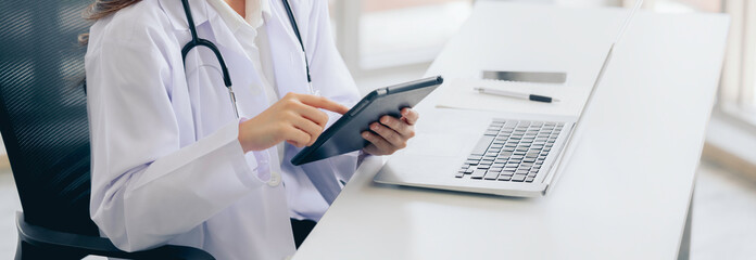 Female doctor using finger touching digital tablet working at hospital,Tele-medical health care...