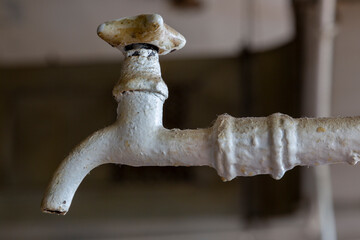 Old white painted water faucet close-up