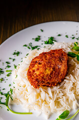 roasted burger with rice in white plate on wooden table background