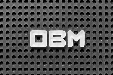 White alphabet letter in word OBM (Abbreviation of Original brand manufacturer) on black pegboard...