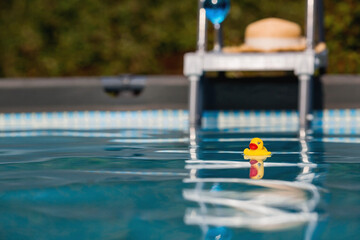 Summer season, the concept of a children's game. Little rubber yellow ducks in the pool. Toys close-up. A symbol of swimming, childhood, friendship, fun game.