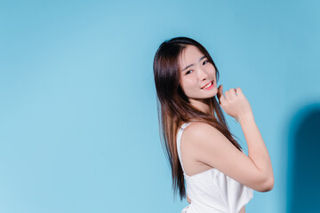 Fototapeta premium Charming asian beauty woman hold sun cream with sun protection uv or sunscreen on the blue background
