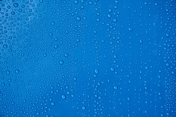 Naklejka na ściany i meble Water drops on blue background.