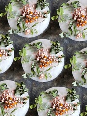A rowan branch with green leaves in ice on a black concrete background. Frozen mountain ash berries pattern. Autumn refreshing concept.
