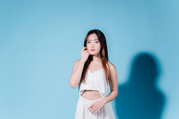 Fototapeta premium Charming asian beauty woman hold sun cream with sun protection uv or sunscreen on the blue background