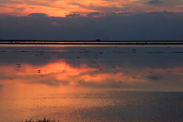 Sunset on the calm water of tha saline