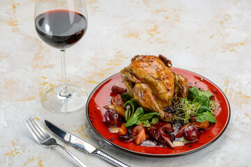 tobacco chicken in a plate with salad on a white background with wine
