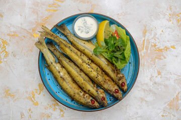 fried chihonya fish in a blue plate on a white background
