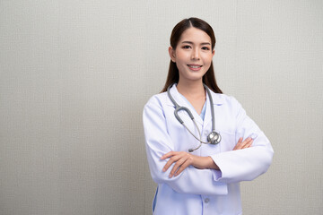 Asian female doctor wearing white medical uniform  He hung a heartbeat meter on his neck, stood with his arms crossed, smiling happily. with confidence isolated with background