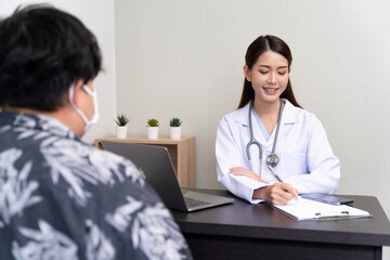 Fototapeta premium A beautiful Asian doctor discusses the condition of a male patient being hospitalized.