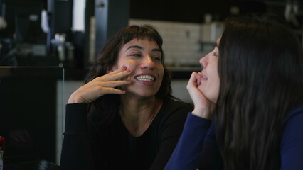 Fototapeta premium Happy women in conversation at cafe restaurant. Two people talking casually