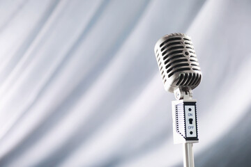 Fototapeta na wymiar Stand with a retro microphone. Microphone on a tripod. Performance of the artist with a vintage microphone. Scene with a microphone.