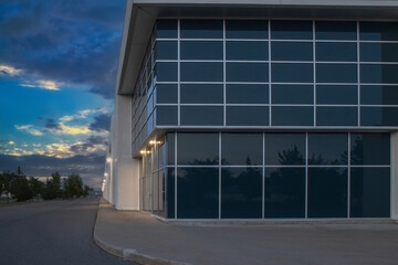 Exterior view of a generic business park building at dusk with multiple high bay units, prefab...
