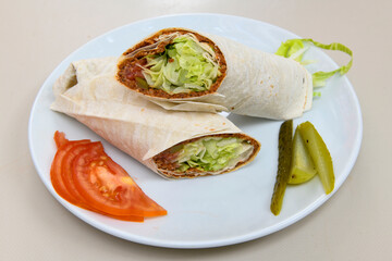 Cig kofte (raw meatball) with lettuce, tomato, pickle and lemon, hot Chee kofta. Turkish local raw food concept.Table scene of assorted take out or delivery foods. Doritoslu cig kofte durum.