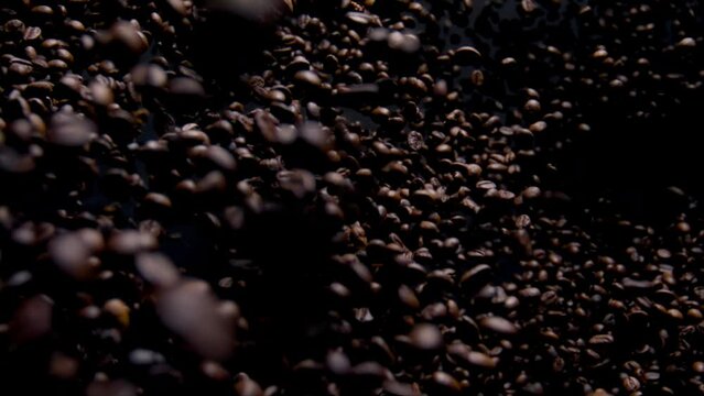 Aromatic coffee grains fly on camera close up. Fragrant brown beans falling.