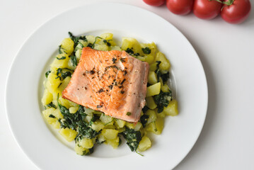 Fried trout served with potatoes and spinach