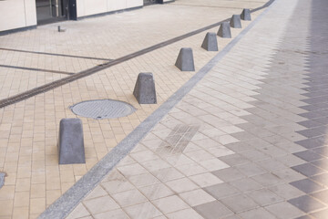 Pavement repair and laying of paving slabs on the walkway, stacked tile cubes on the background. Laying paving slabs in the pedestrian zone of the city, sand filling. Road tiles and curbs.
