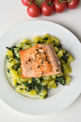 Fried trout served with potatoes and spinach