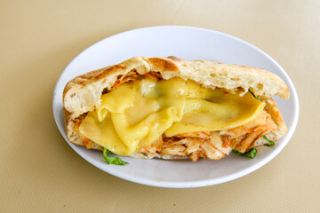 Close-up shot of Izmir's famous Turkish Traditional Kumru Sandwich, Çeşme Kumru, Karisik sandvic,  ingredients ready to eat salami, soudjouk, tomato, cheddar cheese and fried cheese. Yengen sandvic.