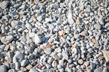 Background from sea pebbles on the beach, close-up. Small and big roundish smooth stones. Texture...