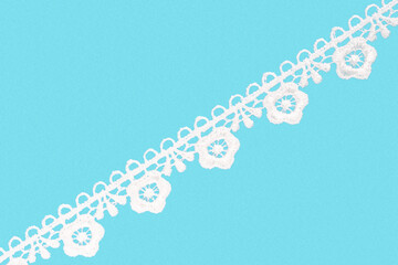 White lace with flowers on blue background isolated diagonally