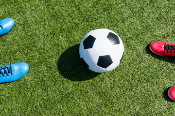 Custom blinds with your photo Soccer football background. Soccer ball and two pair of football sports shoes on artificial turf soccer field with shadow from football goal net on sunny day outdoors. Top view