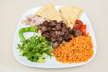 Beef steak grill with rice pilaf, fried potatoes, grilled pepper and tomatoes.Mix Platter with Beef rips, Cutlets, Potatoes and Sauces.