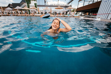 Young woman swimmer in blue pool water