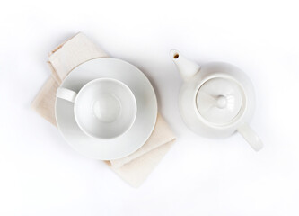Teapot and empty teacup on pale beige cloth isolated on white background