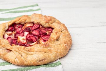 Apple strawberry pie, top view side border against a rustic wood background with copy space. Autumn food concept. Step by step recipe galette