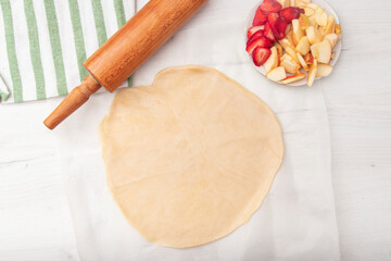 Apple strawberry pie, top view side border against a rustic wood background with copy space. Autumn food concept. Step by step recipe galette