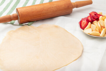 Apple strawberry pie, top view side border against a rustic wood background with copy space. Autumn food concept. Step by step recipe galette