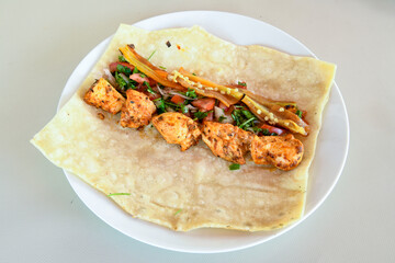 A skewered chicken kebob with grilled onions, bell peppers and delicious white meat with seasoning isolated on a white background. Tavuk sis, Tavuk izgara.