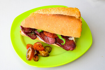 Close-up shot of Izmir's famous Turkish Traditional Kumru Sandwich, Çeşme Kumru, Karisik sandvic,  ingredients ready to eat salami, soudjouk, tomato, cheddar cheese and fried cheese. Yengen sandvic.