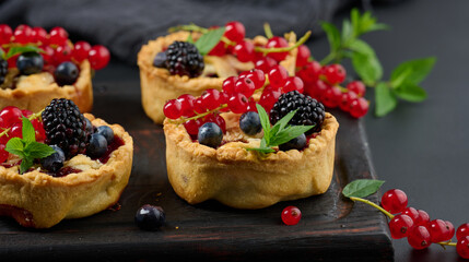 Fruit tart with red currants on a black table
