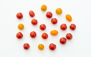 Yellow and red cherry tomatoes on white background