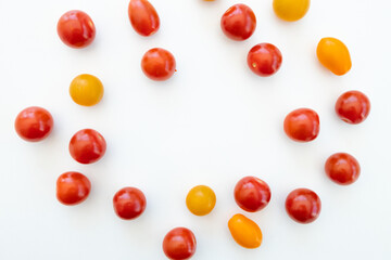 Yellow and red cherry tomatoes on white background
