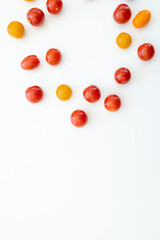 Naklejka na ściany i meble Yellow and red cherry tomatoes on white background