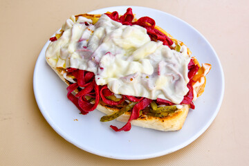 Close-up shot of Izmir's famous Turkish Traditional Kumru Sandwich, Çeşme Kumru, Karisik sandvic,  ingredients ready to eat salami, soudjouk, tomato, cheddar cheese and fried cheese. Yengen sandvic.