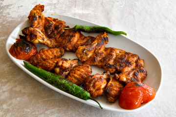 A skewered chicken kebob with grilled onions, bell peppers and delicious white meat with seasoning isolated on a white background. Tavuk sis, Tavuk izgara.