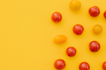 Fresh cherry tomatoes on yellow background