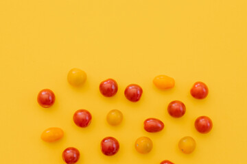 Fresh cherry tomatoes on yellow background