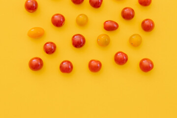 Naklejka na ściany i meble Fresh cherry tomatoes on yellow background