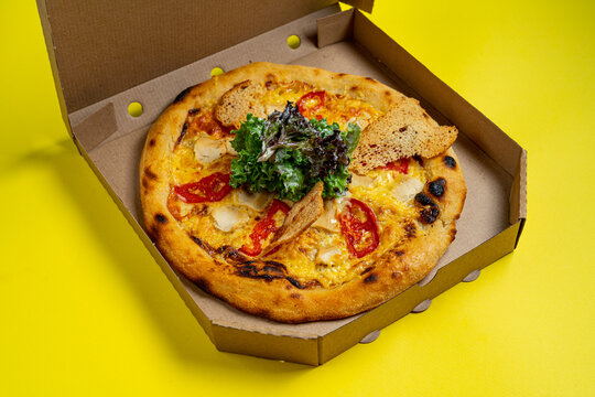 Tasty hawaii pizza in a box isolated on yellow Top view on paperoni pizza. Concept for italian food, street food, fast food, quick bite. Banner with copy space
